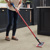 A woman cleaning her Karndean Tortora Breccia Marble stone flooring in her kitchen