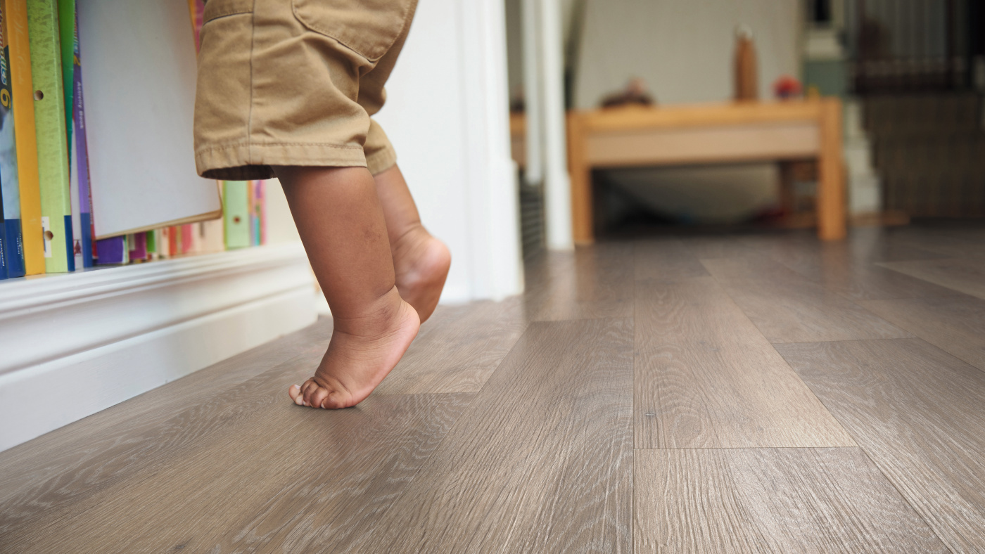 Baby feet stepping on Karndean Rose Washed Oak wood flooring 
